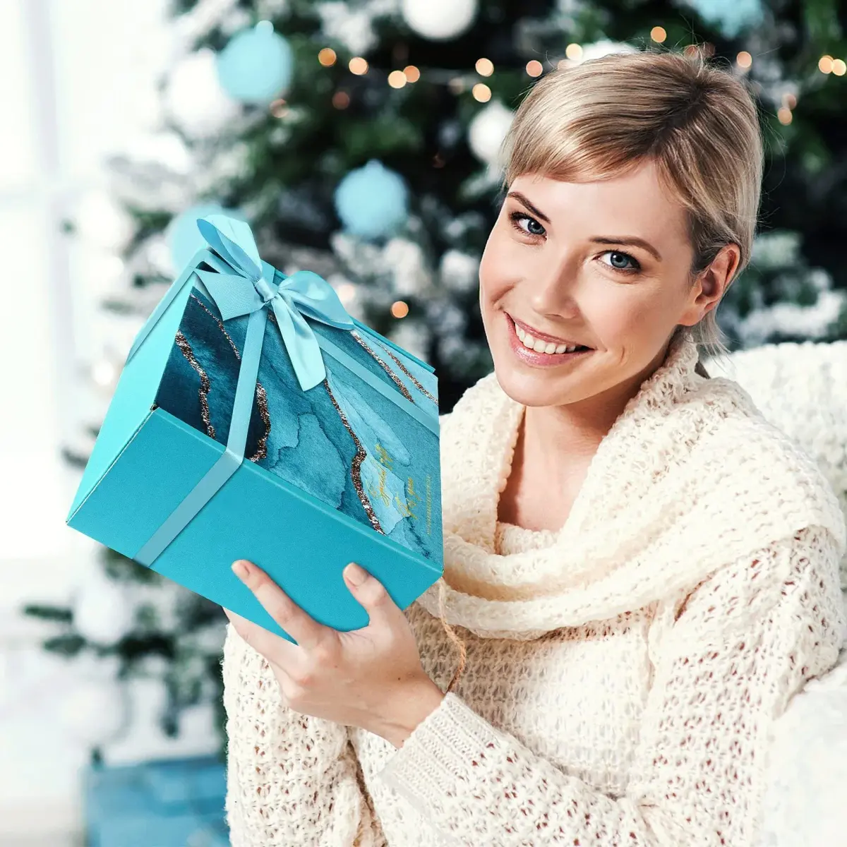 woman smiling with a teal gift box