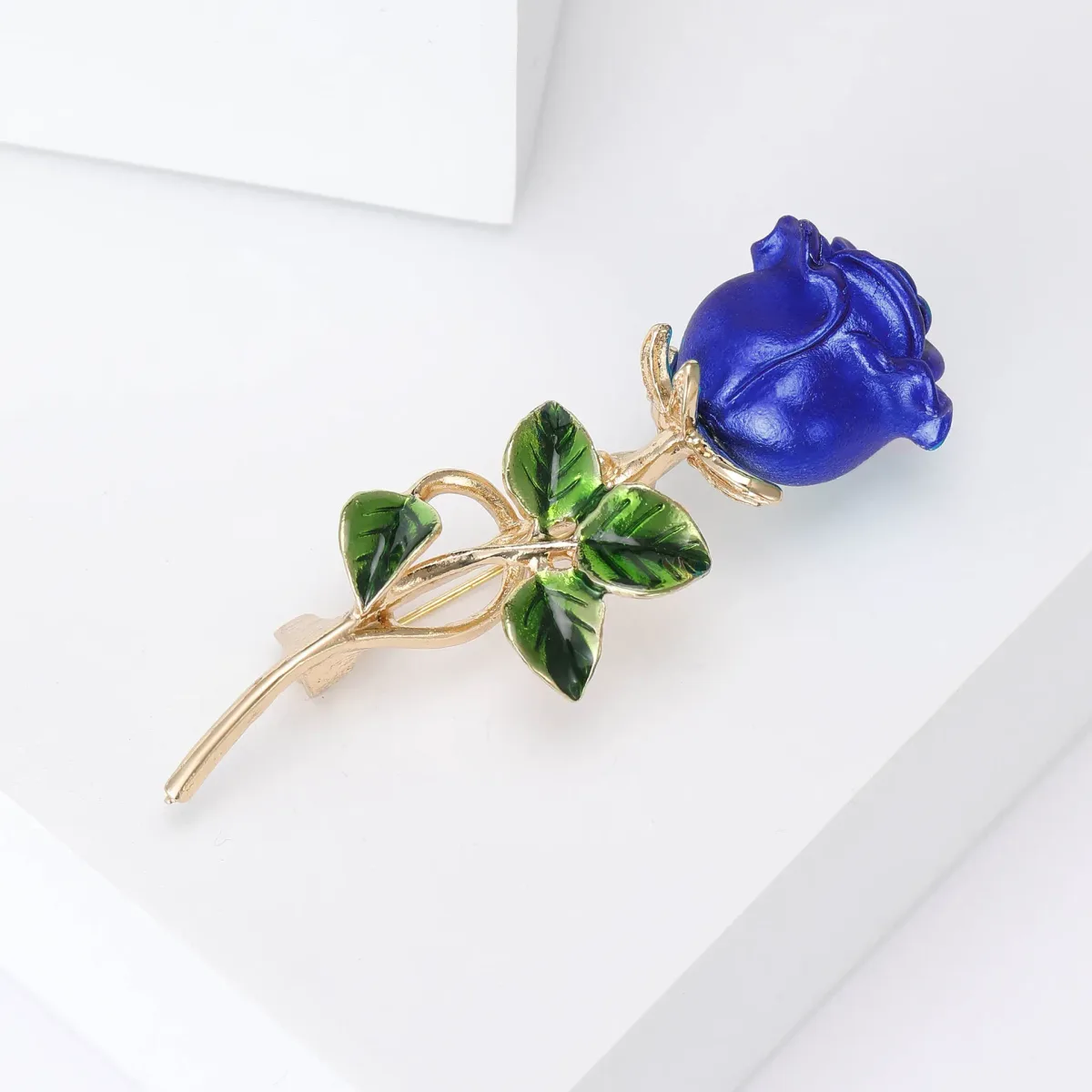 blue rose brooch lying on its side