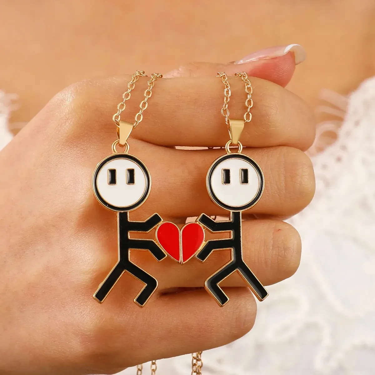 gold tone matching couple pendants held in one hand