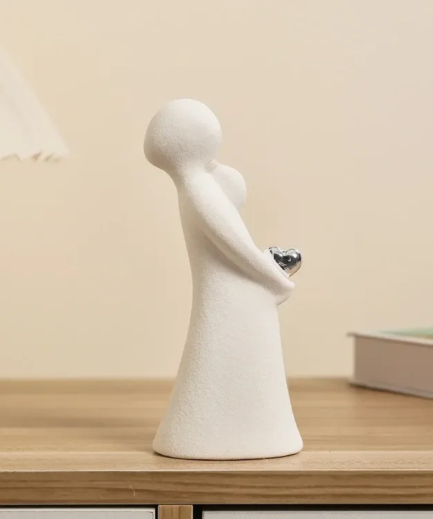 the female ceramic figurine holding a silver tone heart